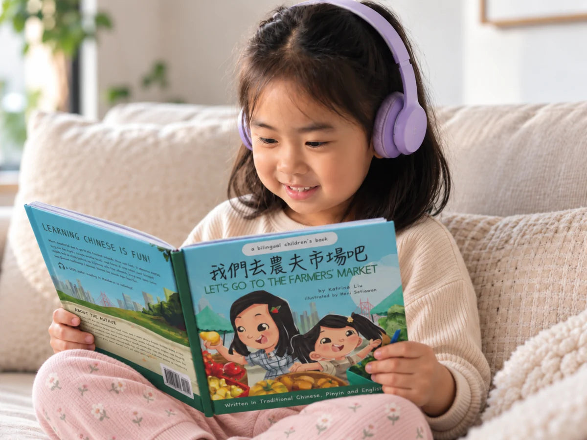 A child wearing headphones reading along with a picture book