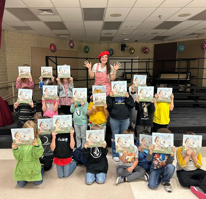 Heatherann Rose at a school visit, children holding up her Rose Sisters Garden Series books